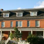 Row of brick townhouses with front porches and gardens