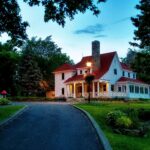 Heritage family home with a red roof on a quiet, tree-lined street in Baie-D'Urfé, West Island