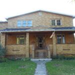 Two-storey house with a wide front porch and lawn in Longueuil